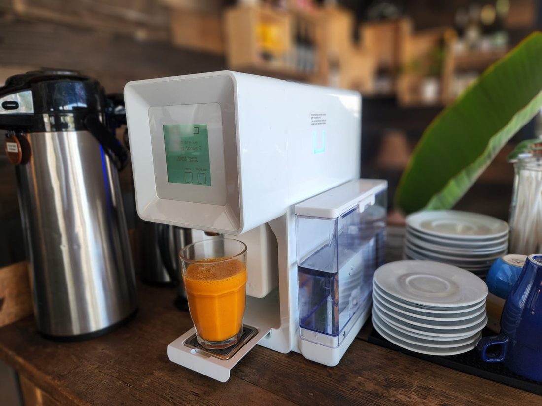 CUBO machine dispensing a fresh enhanced juice on a café countertop